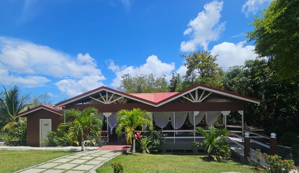 Garden Grove Restaurant open-air pavilion with tropical gardens and blue sky at Royal Escape Villa